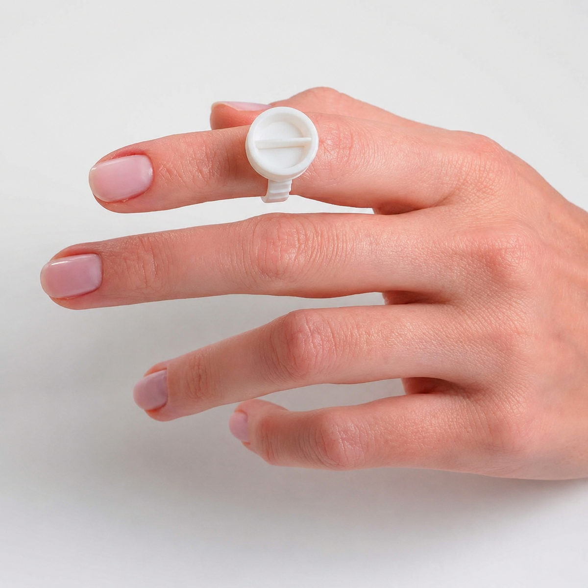 Anello porta pigmento PMU indossato sul dito per uso professionale durante il trattamento
