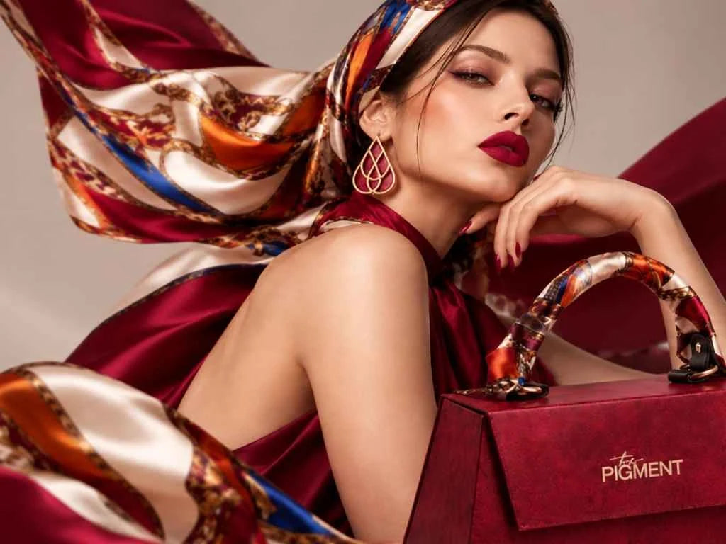 The Pigment: ritratto con labbra rosse e borsa del brand, copertina della collezione pigmenti PMU